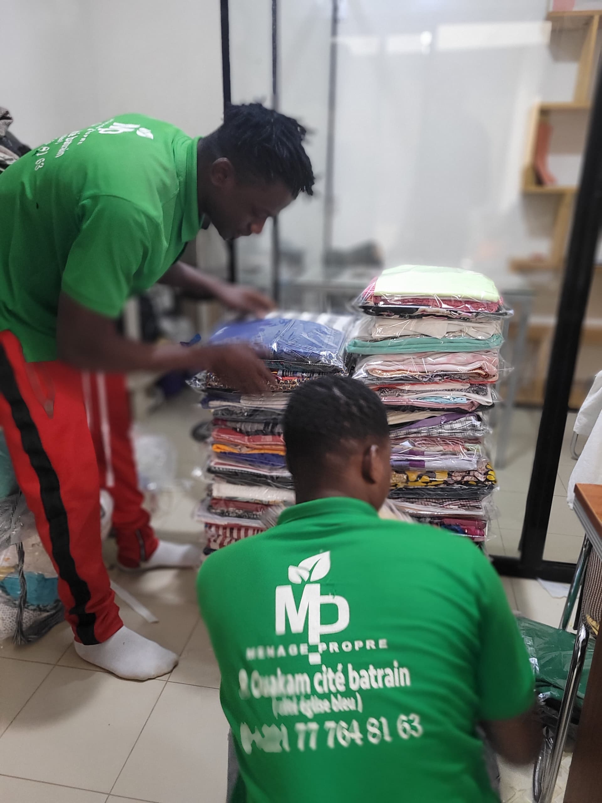 2 employés de menage propre en train de plier les habits